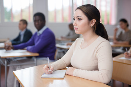 Young woman studying with colleagues at classroomの写真素材