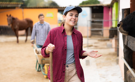 Satisfied woman farmer caring for cows in the backyard of farm