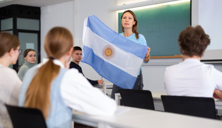Adult female teacher showing Argentina flag to studentsの写真素材