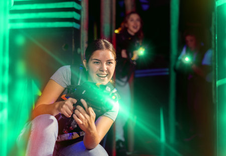 Girl running and dodging while playing lasertagの写真素材