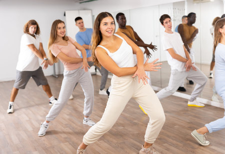 Group of different people rehearsing dance in dance studio