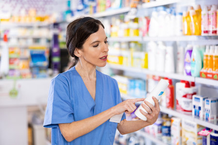 Female pharmacist offering product, working in drugstoreの写真素材