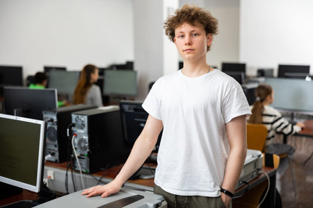 Teenager boy standing in computer class