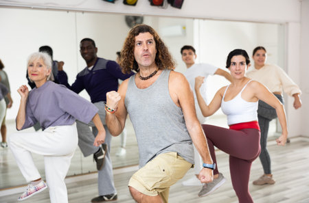 Happy caucasian man learning new modern dance in group dance lesson