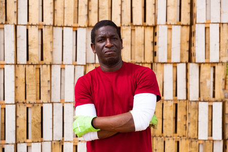 African american farm worker on background with wooden crates