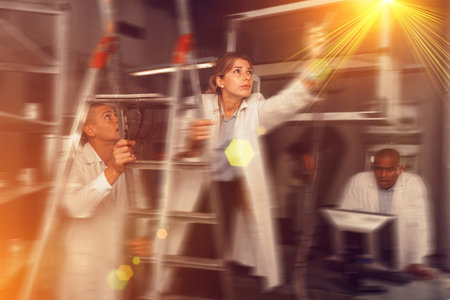 People in white coats are looking for key in a quest room stylized as an laboratory
