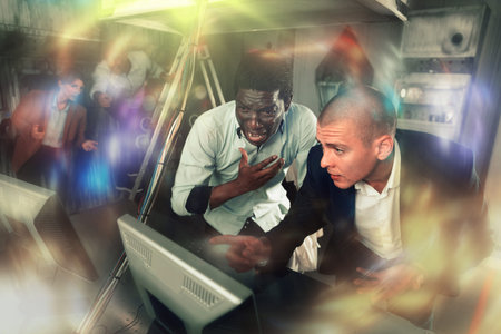 Men in panic looking for a solution on the computer in quest room