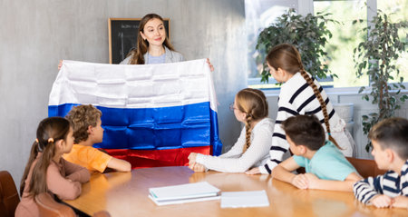 Pupils having lesson of geography. Female teacher discussing with children about national flag of Russiaの写真素材