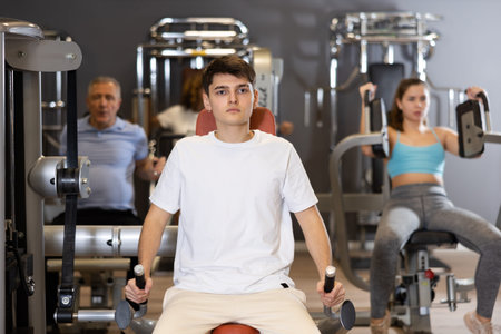Young athlete is engaged in a power simulator in gym