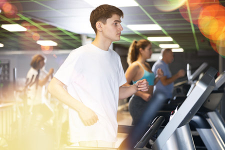 Athletic man exercising on a treadmill in gymの写真素材