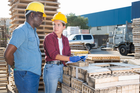 Man and woman in outdoor construction material storage