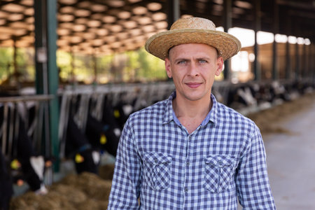 Portrait t worker standing in the yard of a livestock farmの写真素材
