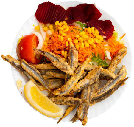 Deep fried anchovies with vegetable garnish and fresh lemonの写真素材