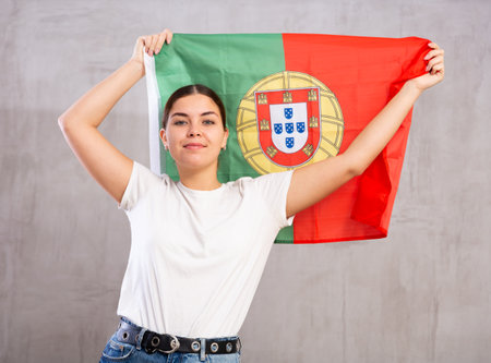 Smiling young woman holding Portugal flagの写真素材