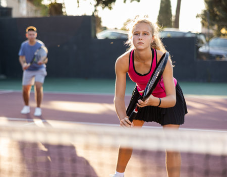 Girl playing tennis match during training on courtの写真素材