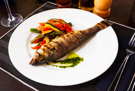 Fried sea bass with vegetables and mushroomsの写真素材