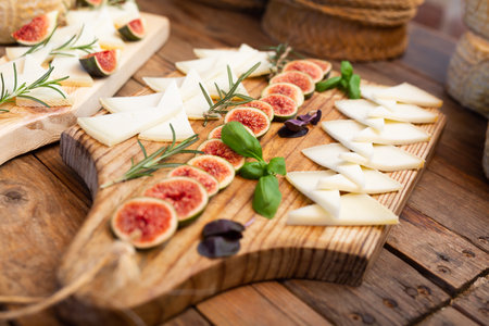 Sliced goat cheese with rosemary, basil and figs for tastingの写真素材