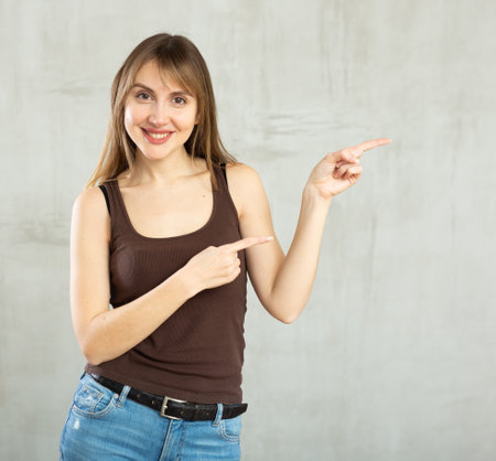 Smiling young woman gesturing in studioの写真素材