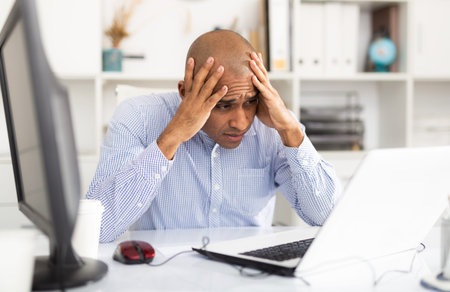 Tired mature office worker at computer