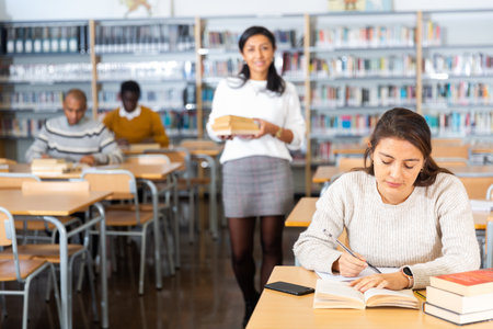 Young adult woman studying in public libraryの写真素材