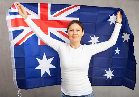 Happy smiling woman proudly displaying australian flagの写真素材
