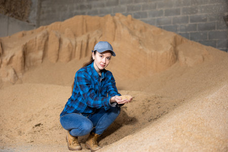 Woman farmer checking quality of soybean huskの写真素材