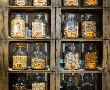 Glass jars with different nuts on grocery store shelvesの写真素材
