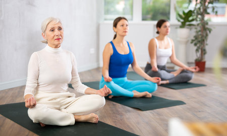 Elderly woman meditating in lotus position with hands in mudraの写真素材