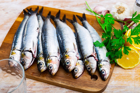 Raw sardines on wooden cutting boardの写真素材