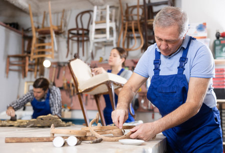 Experienced craftsman cleaning plaque and dirt from wooden vintage partsの写真素材