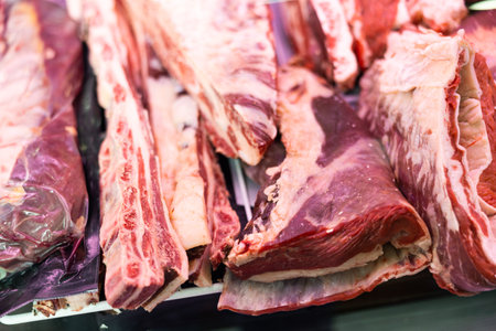 Pieces of raw beef meat lying on counter of butcher shopの写真素材