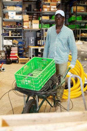 Warehouse worker pushing cart in storage roomの写真素材