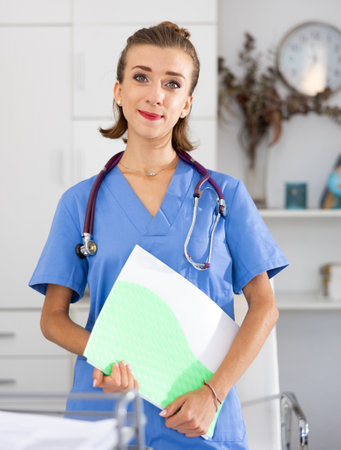 Woman doctor in formal wear standing with folder in officeの写真素材