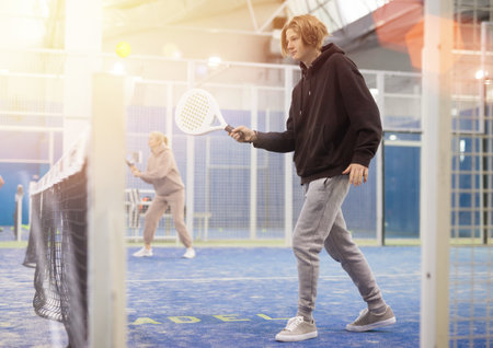 Teenage guy playing paddle tennis on padel courtの写真素材