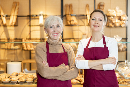 Two happy female bakery workers showing around their workplaceの写真素材