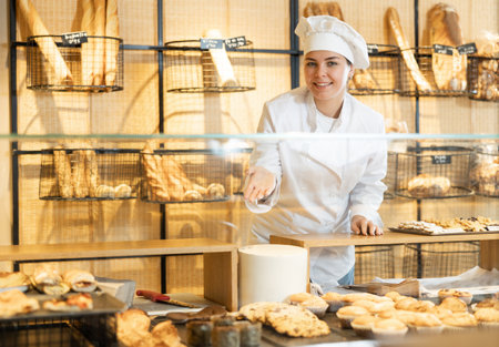 Young female baker presenting fresh baked productsの写真素材