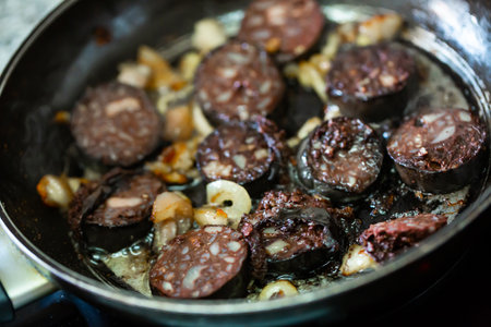 Pan with morcilla sausage slices frying with onionsの写真素材