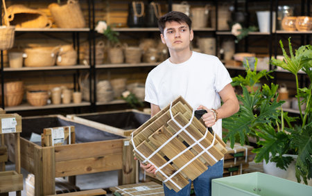 guy choose folding wooden furniture for country house in storeの写真素材