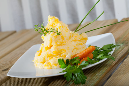 Traditional dish of Scottish cuisine - Clapshot served with baked carrots and greensの写真素材