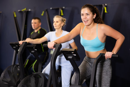 Sporty young woman using elliptical machine in gymの写真素材