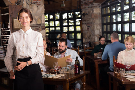 Female owner of country restaurant meeting guestsの写真素材