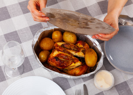 Whole chicken baked with potatoes in tinfoil deep bowlの写真素材