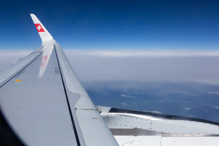 Bern, Switzerland - May 6, 2022: Airplane wing Swiss Airlines with sky from airplane windowのeditorial素材