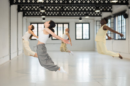Four dancers exercising contemporary dance movementsの写真素材