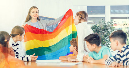 Female teacher explaining lgbt theme to children during lesson in classの写真素材