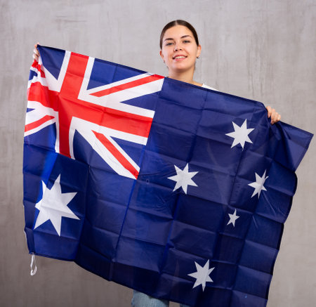 Portrait of positive young woman with flag of Australiaの写真素材