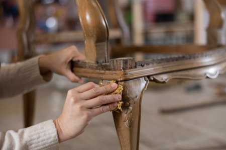 Close up of carpenter using rag while applying protective varnish to piece of woodの写真素材