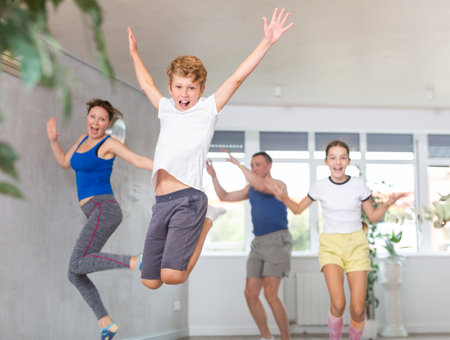 Happy family with son and daughter jumping in gymの写真素材