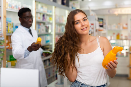 Teenager girl choosing haircare products in drugstoreの写真素材