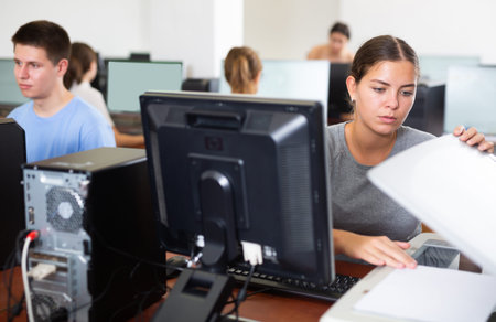 Young woman using scanner in computer class